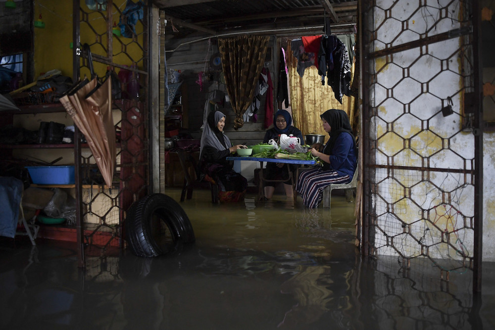 Women prepare dinner in their flooded home in Kampung Lubok Kawah, Besut December 1, 2019. u00e2u20acu201d Bernama pic