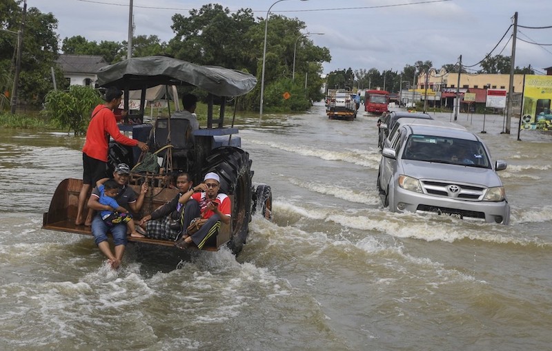 Vehicles travel along a flooded street in Pasir Mas December 2, 2019. — Bernama pic