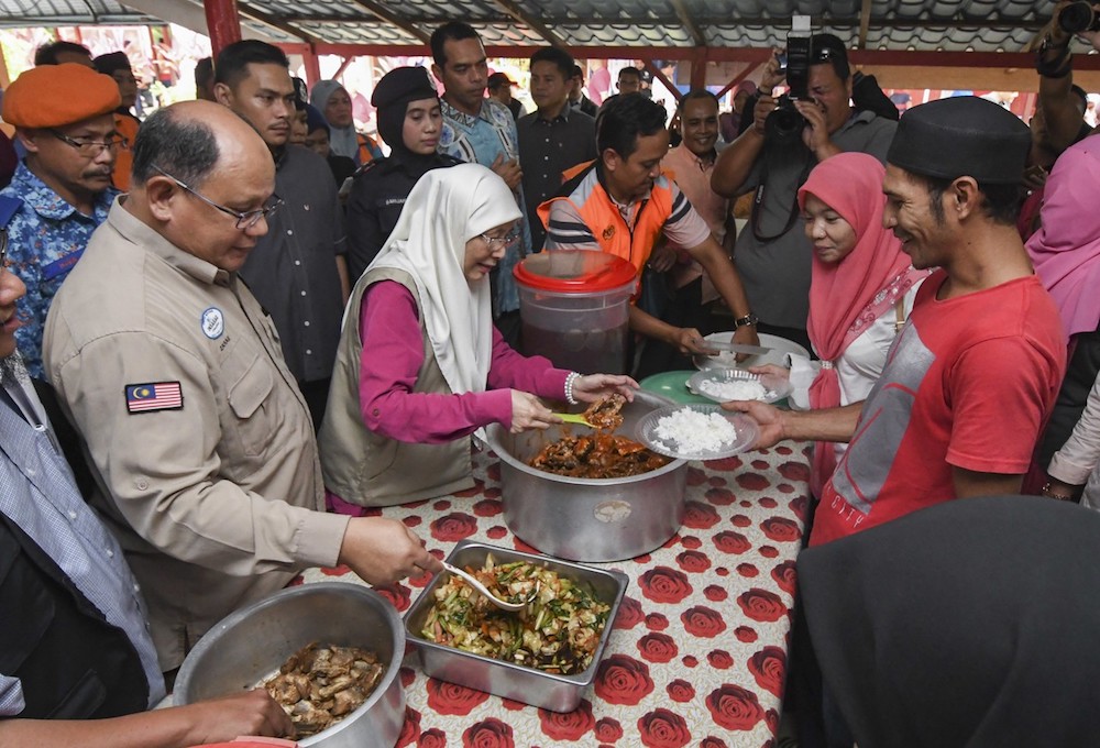 Datuk Seri Dr Wan Azizah Wan Ismail dishes out food to flood evacuees at a relief centre in Sekolah Kebangsaan Kamil 1 in Pasir Puteh December 3, 2019. u00e2u20acu201d Bernama pic