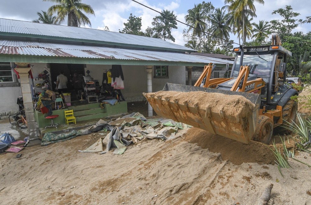A bulldozer is brought in to help clean-up efforts at Kampung Chuchuh Puteri in Kuala Krai December 4, 2019. — Bernama pic