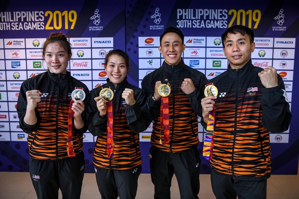 Malaysian divers (from right) Ooi Tze Liang, Chew Yiwei, Wendy Ng Yan Yee and Jasmine Lai Pui Yee pose with their gold medals at the Athletics Stadium in New Clark City December 6, 2019. u00e2u20acu201d Bernama pic