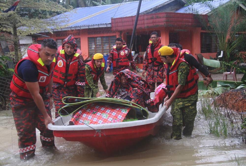 Anggota Bomba membawa mangsa banjir Bahrain Nuai bersama isteri menaiki sebuah bot untuk dipindahkan ke Pusat Pemindahan Banjir. u00e2u20acu201d Foto Bernama