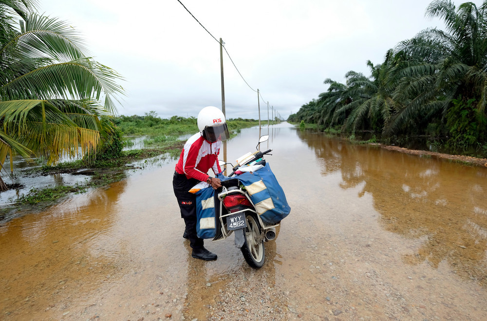 A postman delivers letters in Kampng Denai, Rompin December 18, 2019. u00e2u20acu201d Bernama pic