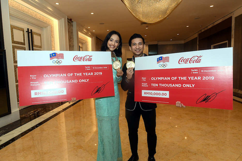 Farah Ann Abd Hadi and Loh Choon How pose with their mock cheques and medals during the 26th Olympic Council of Malaysia Annual Dinner and Awards Night in Kuala Lumpur December 19, 2019. u00e2u20acu201d Bernama pic