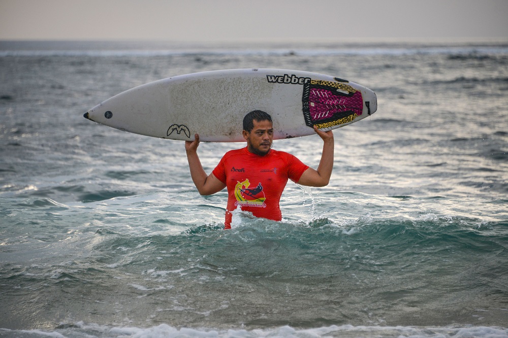 This picture taken on December 9, 2019 shows Dery Setyawan, a survivor of the December 26, 2004 tsunami, holding his surfboard after surfing on Lhoknga beach in Banda Aceh, Aceh province. u00e2u20acu201d AFP pic  