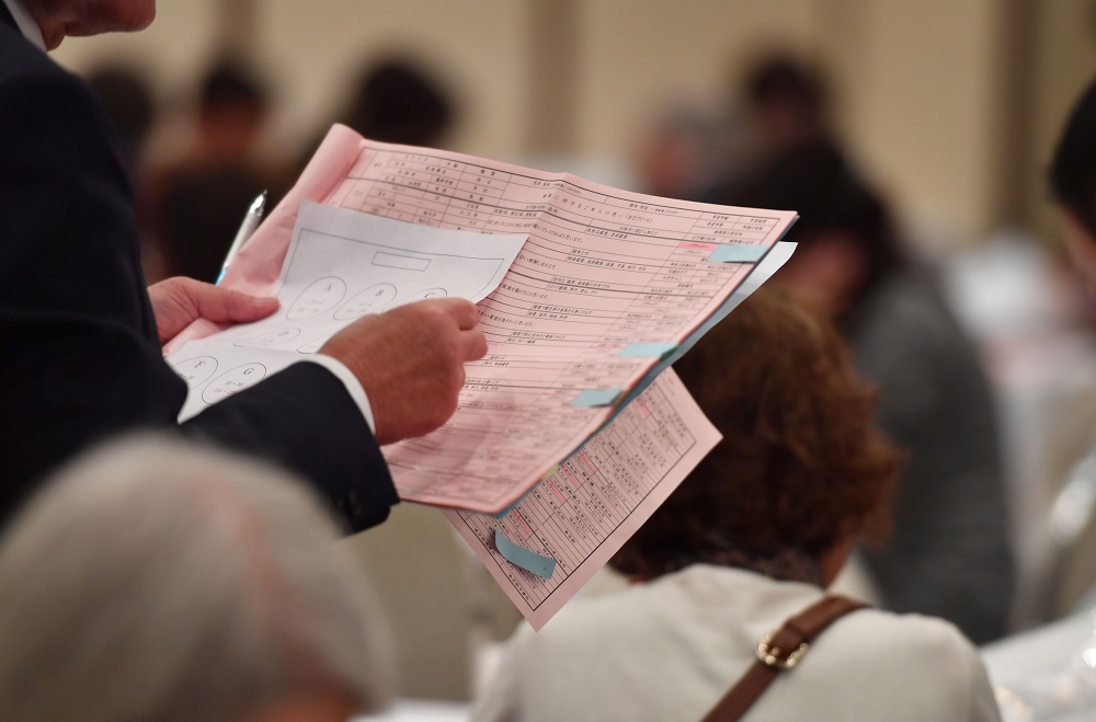 This photo taken on November 3, 2019 shows the father of a participant checking a list of participants during a match-making party in Tokyo. — AFP pic