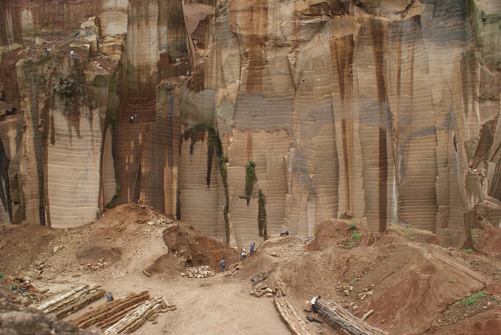 Workers mine rock as trucks wait to transport it to various construction sites in Mutonga quarry, Meru county, Kenya December 2, 2019. u00e2u20acu201dThomson Reuters Foundation pic 