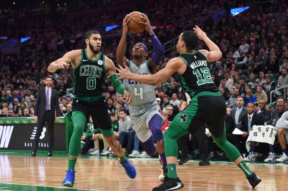 Charlotte Hornets guard Devonte' Graham (4) drives to the basket between Boston Celtics forward Jayson Tatum (0) and forward Grant Williams (12) during the first half at TD Garden. u00e2u20acu2022 Bob DeChiara-USA TODAY Sports pic via Reuters