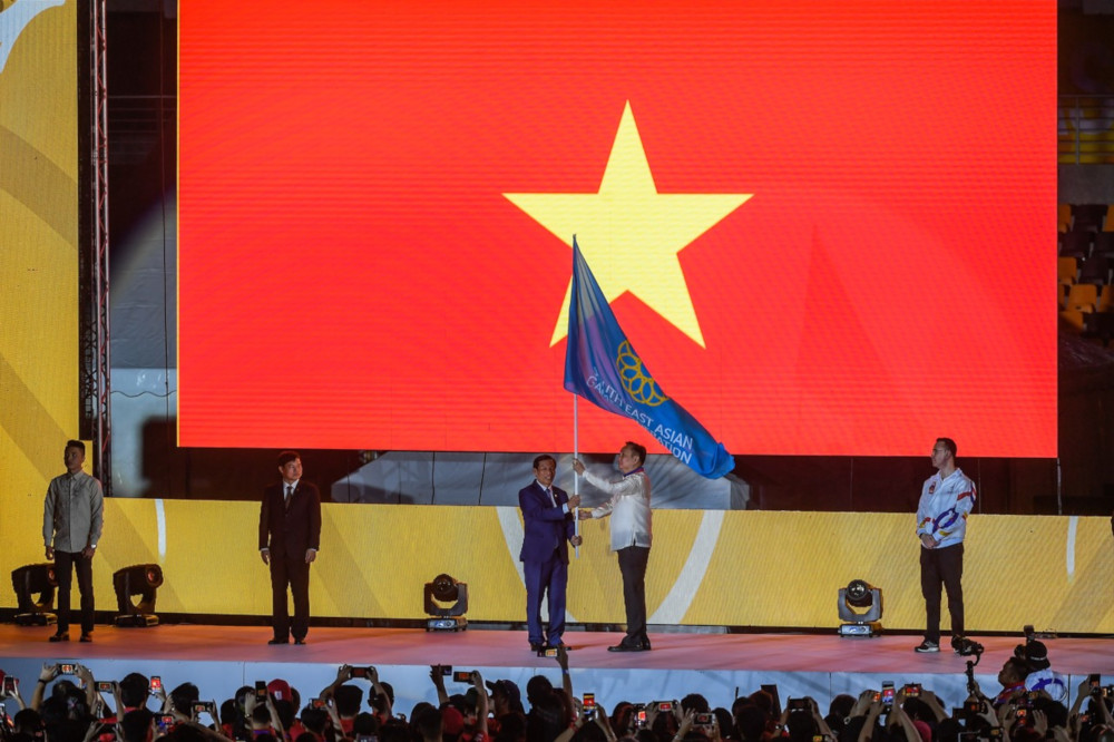 Philippine SEA Games Federation president Abraham Tolentino passes the SEA Games flag to Vietnam Minister of Culture, Sports and Tourism Nguyen Ngoc Thien at the official closing ceremony of the 30th SEA Games at the Clark City Athletics Stadium December 