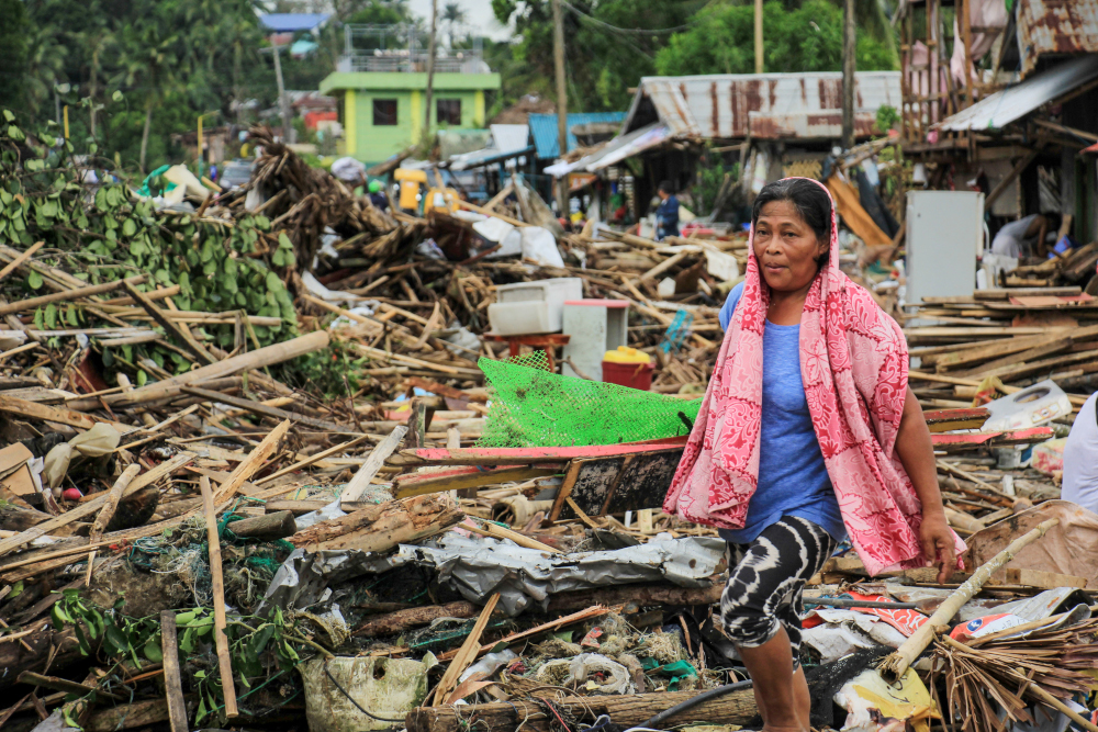 A resident walks past debris from their destroyed houses after Typhoon Kammuri hit the city of Sorsogon, south of of Manila December 3, 2019. u00e2u20acu201d AFP pic 