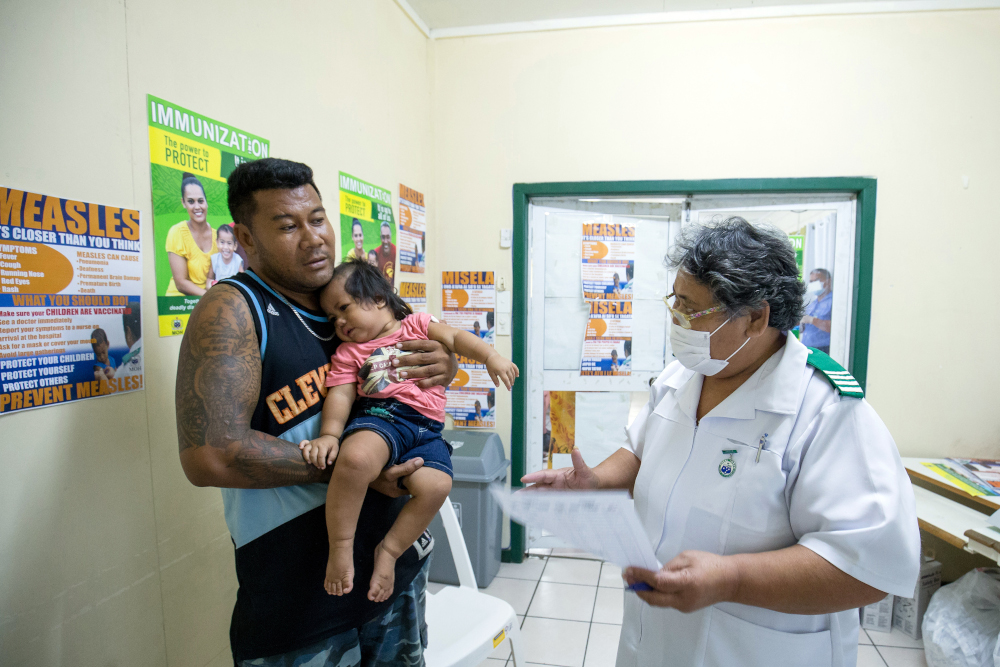 This handout picture taken December 4, 2019 by Unicef Samoa shows nurse Fau00e2u20acu2122atafa Tavita speaking with a family at the Apia Town Clinic in Samoau00e2u20acu2122s capital city Apia. u00e2u20acu201d Allan Stephen/Unicef handout pic via AFP  