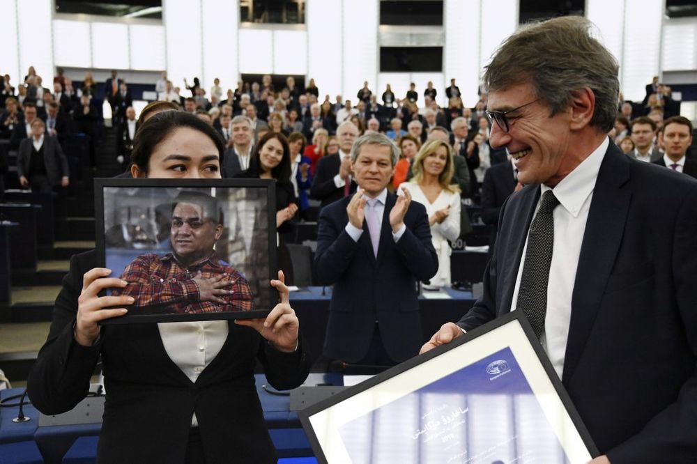 European Parliament President David-Maria Sassoli (right) stands next to Jewher Ilham, daughter of Ilham Tohti, Uyghur economist and human rights activist, holding a portrait of her father during the award ceremony for his 2019 European Parliamentu00e2u20acu2122s