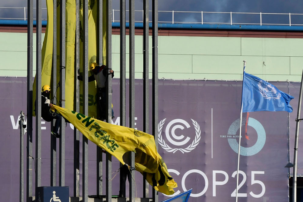 Greenpeace activists try to unfold a banner reading u00e2u20acu02dcClimate is not a businessu00e2u20acu2122 during the UN Climate Change Conference COP25 at the u00e2u20acu02dcIFEMA u00e2u20acu201d Feria de Madridu00e2u20acu2122 exhibition centre, in Madrid, December 13, 2019. u00e2u20acu201d AFP pic 