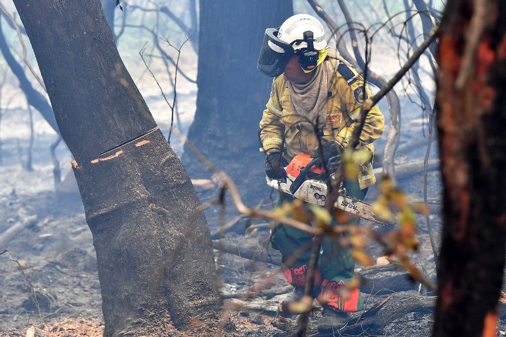 Volunteer firefighter Andrew Moyle cutting down burnt trees in Dargan, some 120 kilometres from Sydney, December 18, 2019. u00e2u20acu201d AFP pic