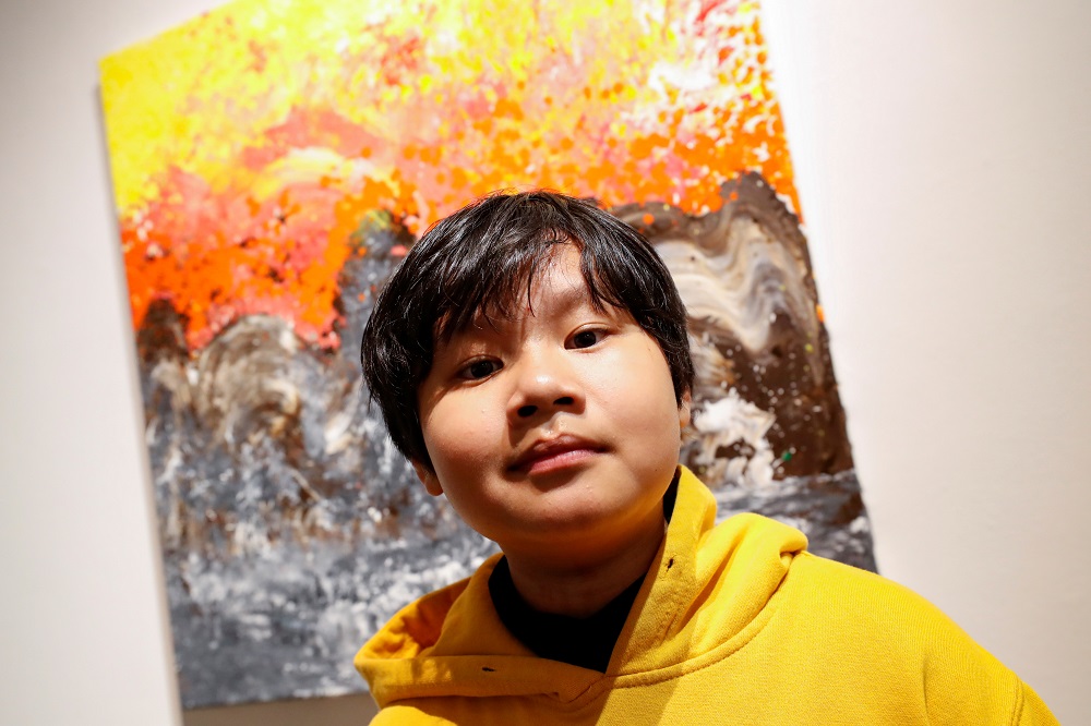 Xeo Chu, a Vietnamese art prodigy, poses in front of one of his pieces before his debut solo exhibition at the Georges Berges Gallery in New York City, New York December 18, 2019. ― Reuters pic
