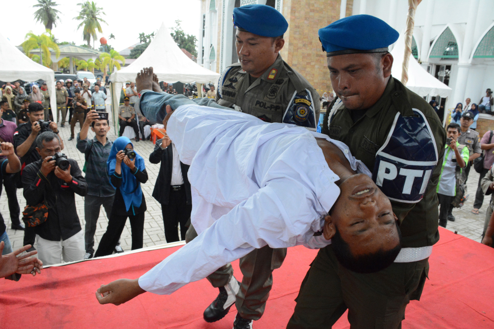 An Indonesian man faints after he was whipped in public on charges of engaging in sexual relations, in Aceh Timur December 5, 2019. u00e2u20acu201d AFP pic 