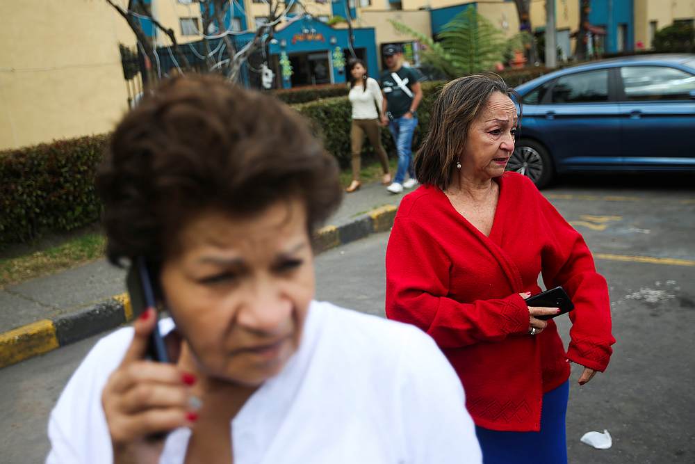 People hold their cellphones as they react after an earthquake in Bogota, Colombia December 24, 2019. u00e2u20acu201d Reuters pic