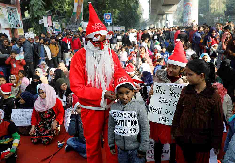 A man wearing a Santa Claus costume gives hats to kids during a protest against a new citizenship law, outside the Jamia Millia Islamia university in New Delhi, India December 25, 2019. u00e2u20acu201d Reuters pic 