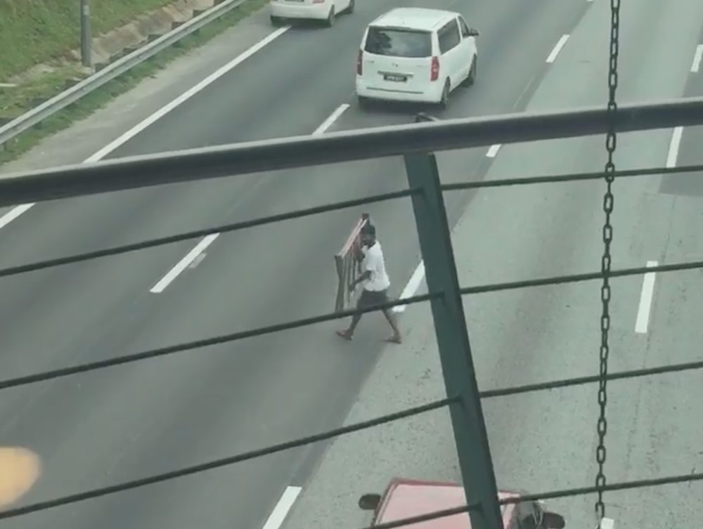 The man leaps into action after spotting the scrap metal lying in the middle of the highway. u00e2u20acu201d Screengrab from Facebook/xidi.zaid