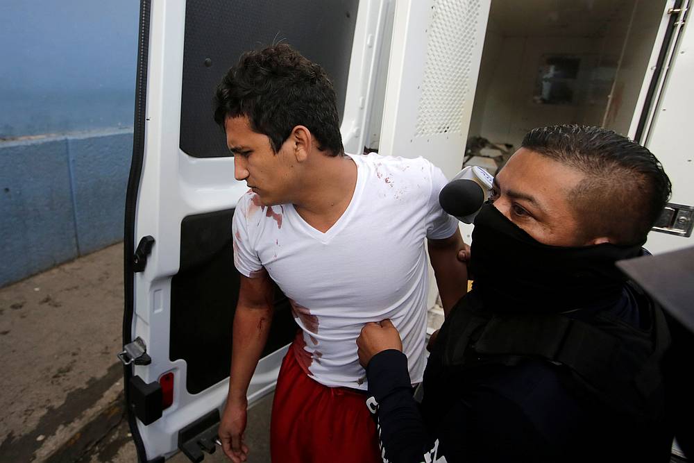 A policeman escorts an inmate injured during a fight at El Porvenir prison, as they arrive at a hospital in Tegucigalpa, Honduras December 22, 2019. u00e2u20acu201d Reuters pic