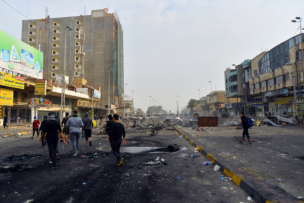 Iraqis walk past a metal barrier in the southern Iraqi Shiah holy city of Najaf December 1, 2019. u00e2u20acu201d AFP pic