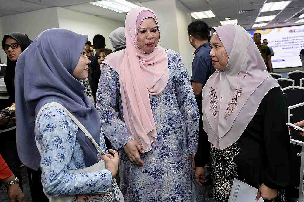 Rina having a chat with a future polytechnic student and her mother after the cheque presentation. — Picture by Miera Zulyana