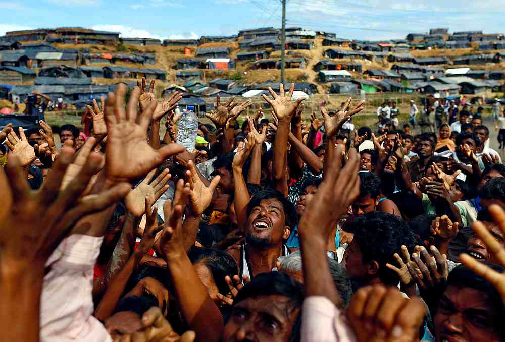 Rohingya refugees stretch their hands to receive aid distributed by local organisations at Balukhali makeshift refugee camp in Cox's Bazar, Bangladesh September 14, 2017. u00e2u20acu201d Reuters pic