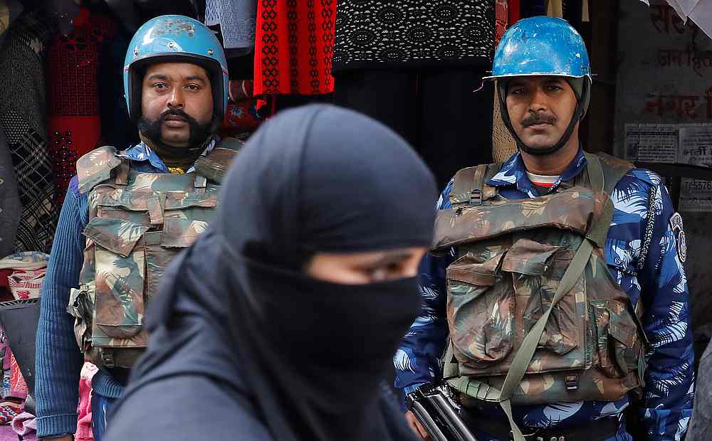 A veiled Muslim woman walks past riot police in a street in Meerut, in the northern state of Uttar Pradesh, India December 27, 2019. u00e2u20acu201d Reuters pic