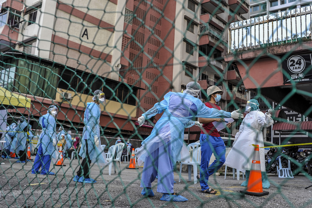 Health workers directing members of the public to the testing area for Covid-19 at Flat PKNS Kampung Baharu in Kuala Lumpur April 12, 2020. u00e2u20acu201d Picture by Shafwan Zaidon