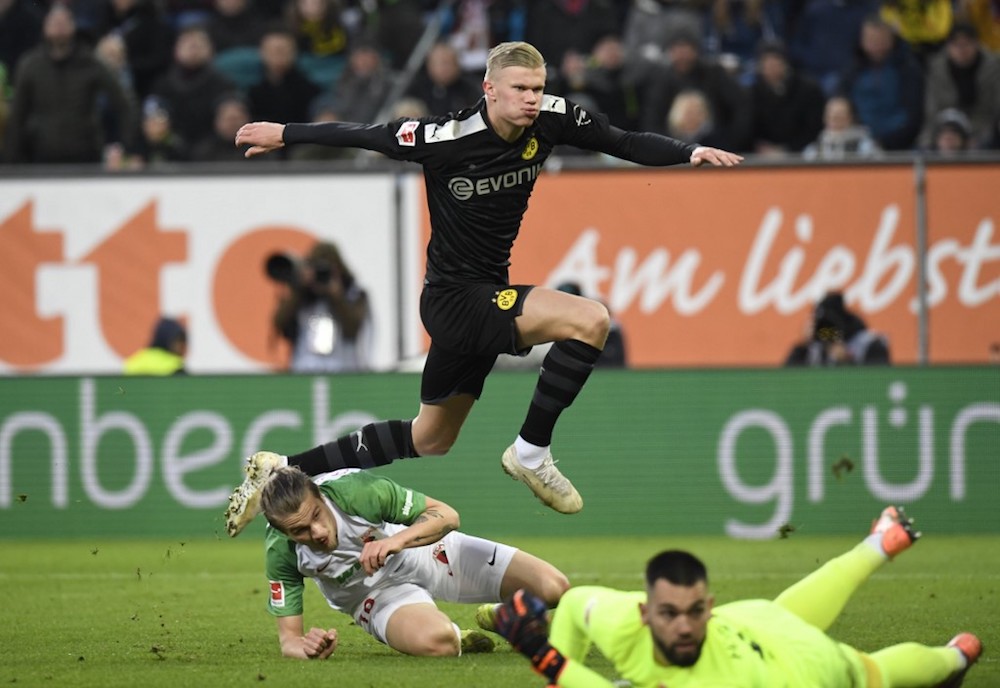 Dortmundu00e2u20acu2122s Erling Braut Haaland jumps over Augsburgu00e2u20acu2122s goalkeeper Tomas Koubek and defender Tin Jedvaj after he scored during their Bundesliga match in Augsburg January 18, 2020. u00e2u20acu201d AFP pic