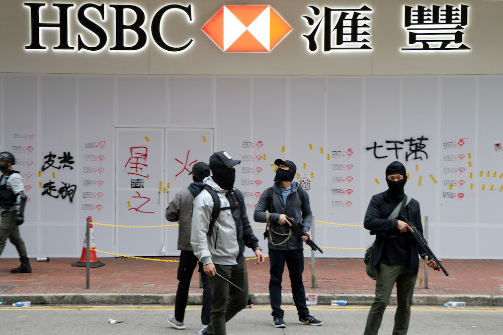 Armed undercover police officers guard a vandalised HSBC bank branch in Wan Chai during demonstrations on New Year's Day in Hong Kong January 1, 2020. u00e2u20acu201d Reuters pic