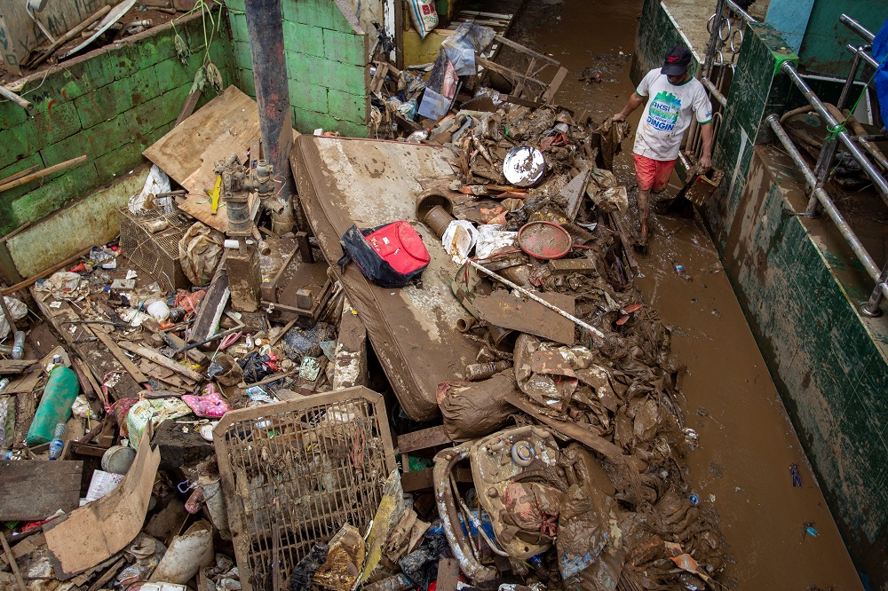 A man cleans up the clay after floods hit in Jakarta January 3, 2020. u00e2u20acu201d Antara Foto/Dhemas Reviyanto/via Reuters