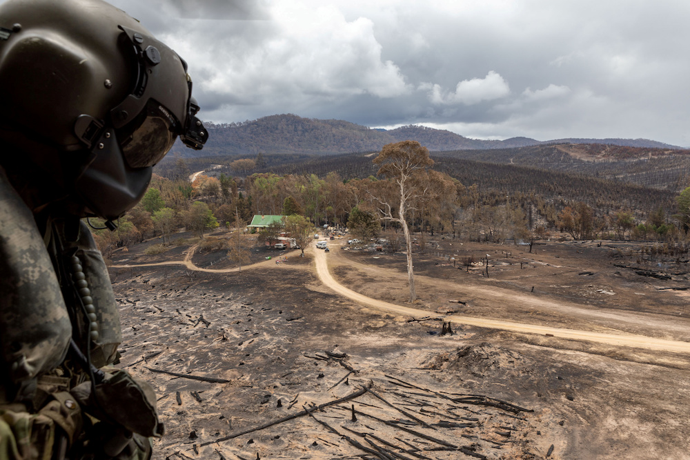 Leading Seaman Aircrewman Brendan Menz keeps watch as HMAS Choules’ MRH-90 Maritime Support Helicopter lands in a burnt-out field in southern New South Wales January 9, 2020. — Reuters pic