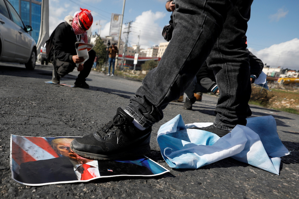 A Palestinian demonstrator steps on a poster depicting US president Donald Trump during a protest against Trump's Middle East peace plan, near the Jewish settlement of Beit El in the Israeli-occupied West Bank January 30, 2020. u00e2u20acu201d Reuters pic