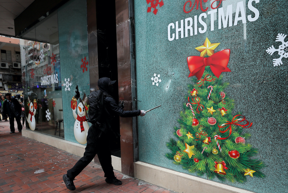 An anti-government protester vandalizes a bureau of the China Life Insurance Company during demonstration on New Year's Day, to call for better governance and democratic reforms in Hong Kong January 1, 2020. u00e2u20acu201d Reuters picn n