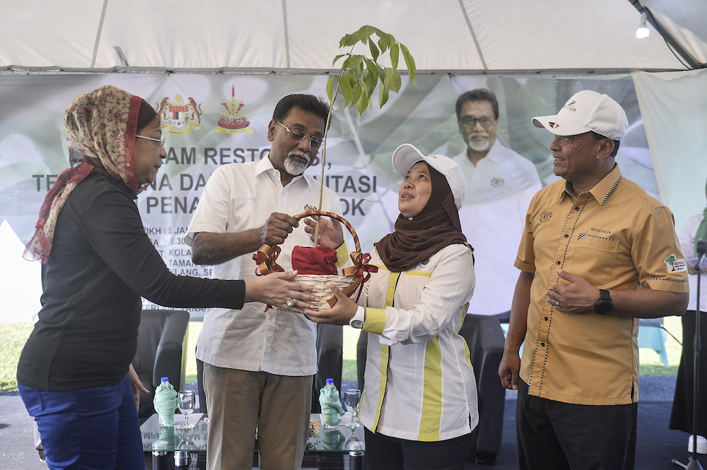Datuk Dr Xavier Jayakumar gives a sapling to Klang Municipal Council secretary Elya Marini Darmin during the launch of the Restoration, Reclamation and Rehabilitation Through Tree Planting Programme in Klang January 5, 2020. u00e2u20acu201d Picture by Miera Zulyana