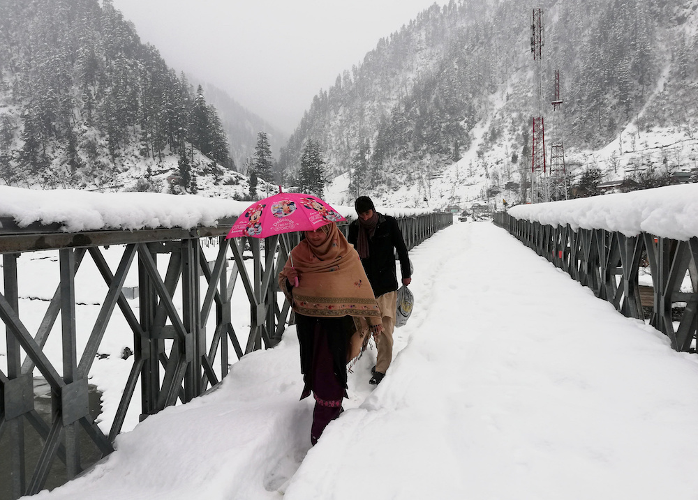 People walk on a snow-covered bridge after a heavy snowfall in Neelum Valley near the Line of Control (LoC), Pakistan, January 15, 2020. u00e2u20acu201du00c2u00a0Reuters pic
