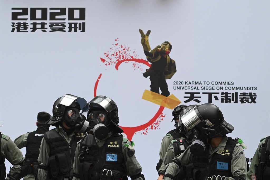 Riot police stand before a protest backdrop after police dispersed a crowd gathered for the 'universal siege on communists' rally at Chater Garden in Hong Kong on January 19, 2020. — AFP pic
