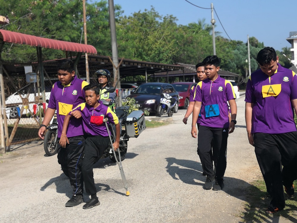 Haikal, aided by his friend, walks along the course during SMK Muadzam Shahu00e2u20acu2122s annual school road run.u00e2u20acu201dPicture via Facebook/SMK Muadzam Shah The Official
