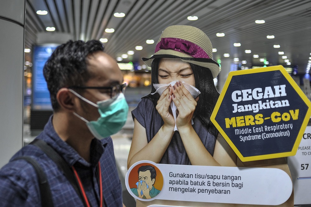 A man walks by a standee displaying information on MERS-CoV at the arrival hall in KLIA 2, Sepang January 27, 2020. u00e2u20acu201d Picture by Shafwan Zaidon