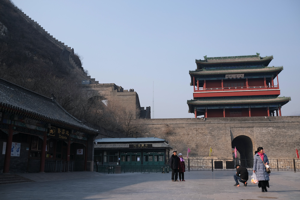 People pose for pictures in front of an entrance to the Juyongguan section of the Great Wall, which is closed to visitors, according to a notice in its tickets office for the safety concern following the outbreak of a new coronavirus, near Beijing, China 