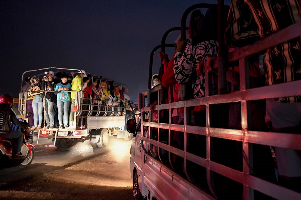 This picture taken on December 12, 2019 shows garment factory workers standing in a truck, which they use to commute to and from work, in Kampong Speu province. u00e2u20acu201d AFP pic 