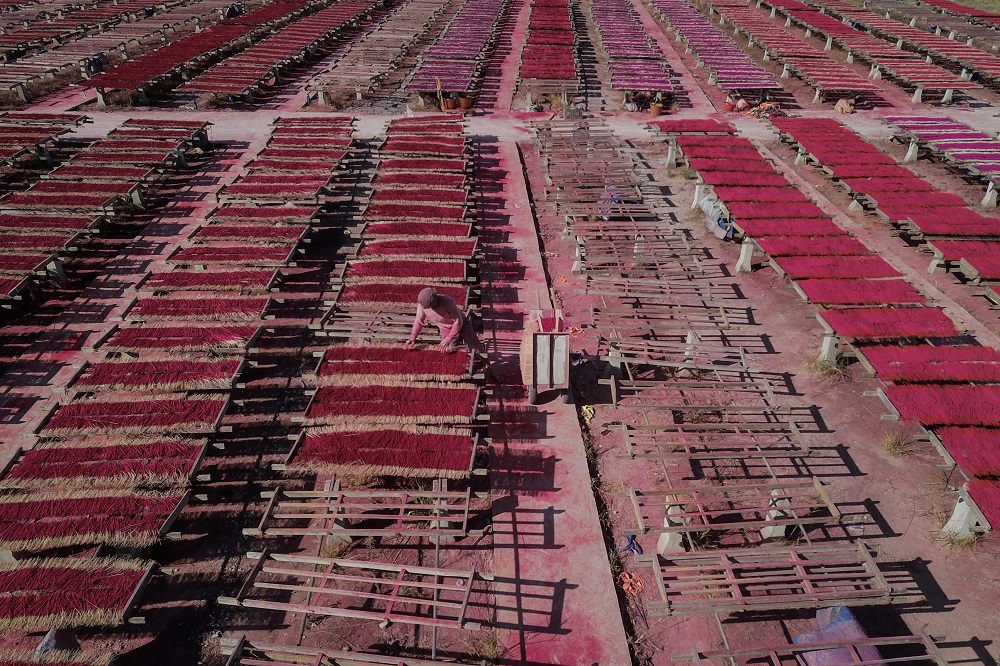 This overhead photo taken on December 11, 2019 shows a worker placing incense sticks on wooden platforms to dry at the Fujian Xingquan Incense Factory in the city of Quanzhou in China’s Fujian Province. — AFP pic  