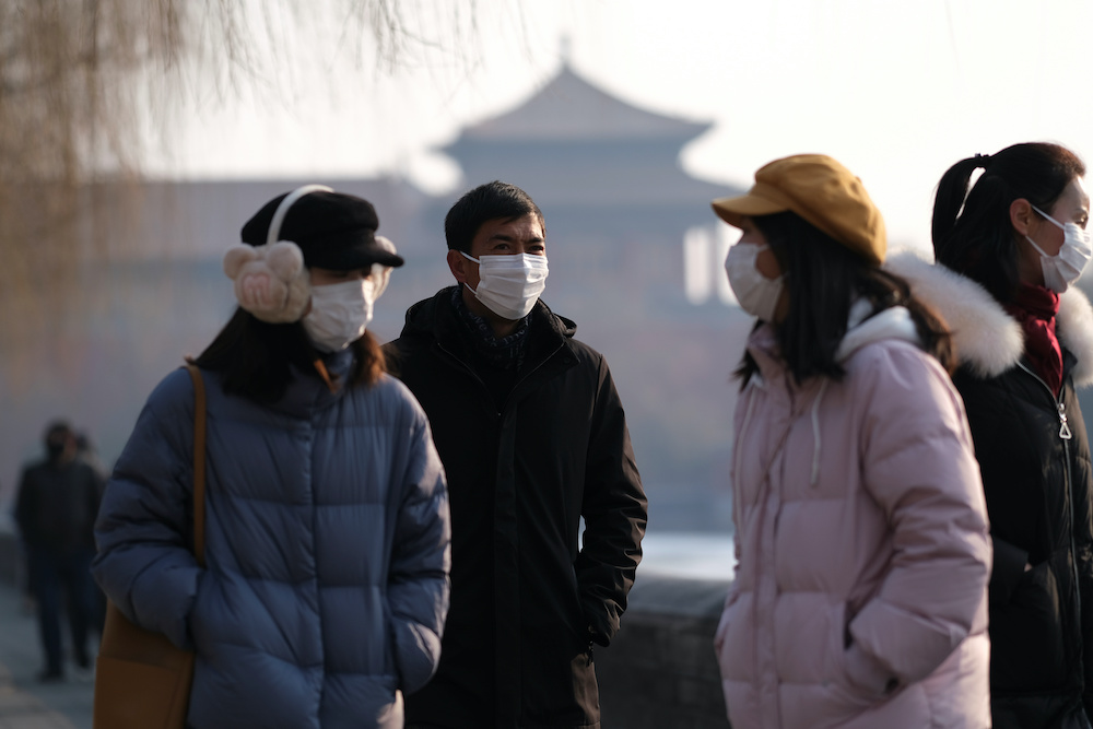 People wearing protective masks walk outside Forbidden City which is closed to visitors, according to a notice in its main entrance for the safety concern following the outbreak of a new coronavirus, in Beijing, China January 25, 2020. u00e2u20acu201d Reuters pic