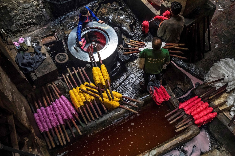 Workers dye yarns at a traditional hand-dying workshop in the Egyptian capital Cairou00e2u20acu2122s centuries old district of Darb al-Ahmar January 21, 2020. u00e2u20acu201d AFP pic