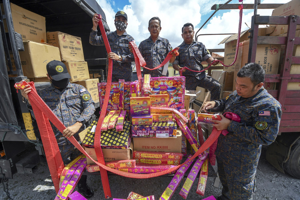 Kelantan Aksem commander Rusli Karim (centre) and members of his force show some of the 84 boxes of firecrackers that were seized in Machang, at the Aksem Office in Kota Baru January 5, 2020. u00e2u20acu201d Bernama pic