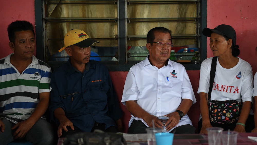 Warisan candidate Datuk Karim Bujang speaks to people at their home in Kampung Kelatuan, Papar January 8, 2020. — Bernama pic