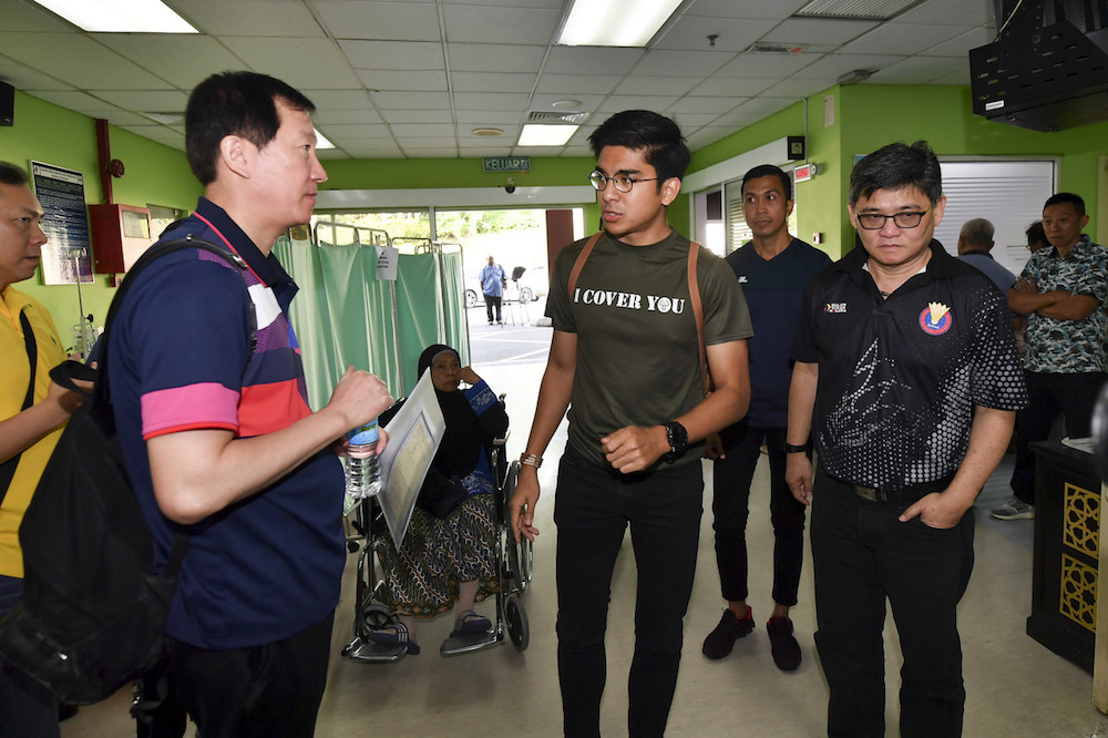 Youth and Sports Minister Syed Saddiq Abdul Rahman speaks to Japan national head coach Park Joo-bong at Putrajaya Hospital January 13, 2020. — Bernama pic