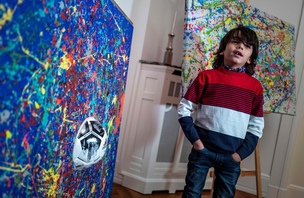 German artist Mikail Akar poses with his u00e2u20acu02dcChampiu00e2u20acu2122 painting (right) and a print edition of the painting he produced with German goalkeeper Manuel Neuer called u00e2u20acu02dcManus 11u00e2u20acu2122, prior to his u00e2u20acu02dcManus 11u00e2u20acu2122 exhibition in Berlin December 13, 2019. u00e2u20acu201d AFP p