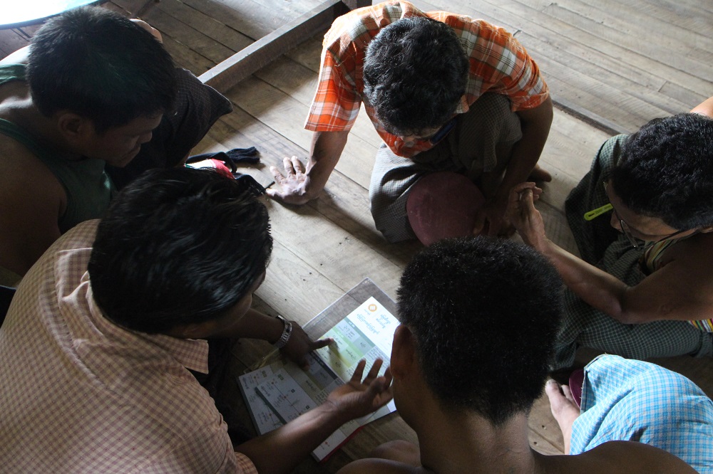 A member of staff from Proximity Designs explains the results of soil tests to farmers in Mawlamyaing Kyun Township in the Ayeyardwady delta in southern Myanmar, taken on October 28, 2019. — Thomson Reuters Foundation pic
